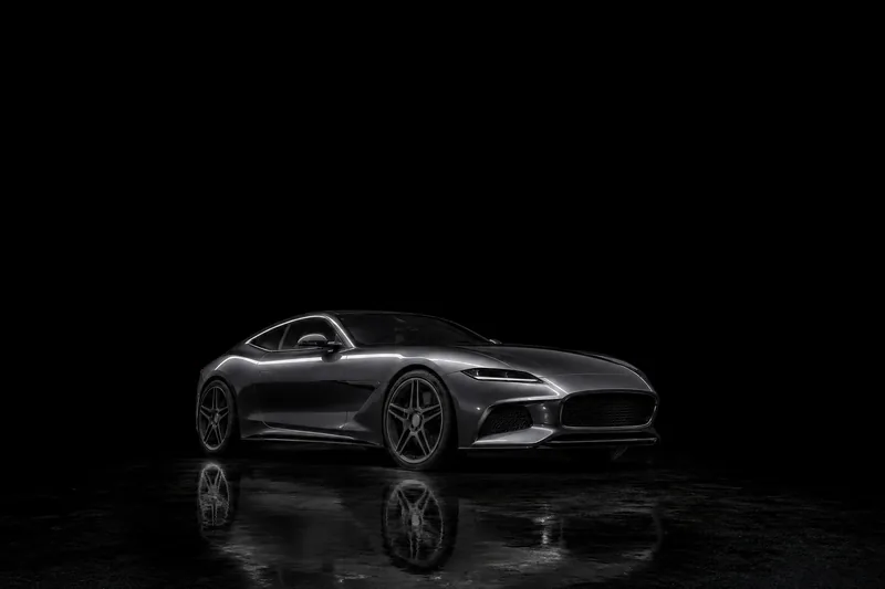 A graphite grand tourer in a black studio, one strip light along its shoulder.